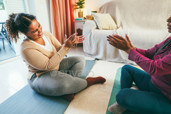 Mom and daughter celebrating after yoga class collectively at home