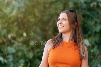 Cushty woman smiling while taking half in a summer season day within the park.