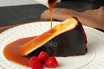 A part of cheesecake with pouring caramel sauce on plate