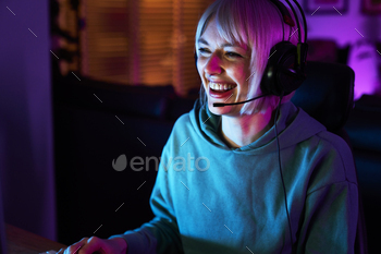 Caucasian young girl taking half in game at night amongst neon lightning