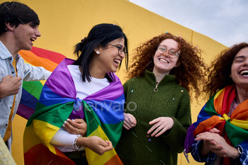 Team enraged younger various folk laughing yellow wall background. LGBT neighborhood having fun with pride.