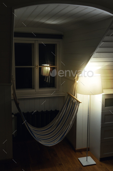 Comfy interior with a hammock in evening room