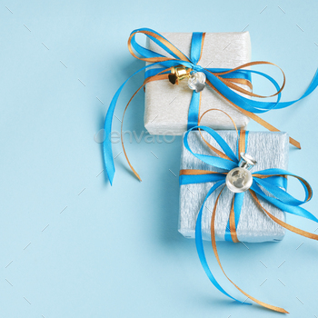 Two gift boxes wrapped in white and blue silver paper. Christmas and New Year items, Boxing Day.