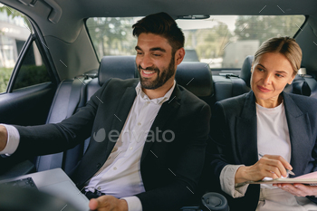 Smiling enterprise analysts bask in on-line meeting using computer while sitting in automobile assist seats