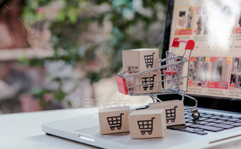 Cardboard field with a having a be taught about cart ticket in a trolley on notebook computer keyboard.