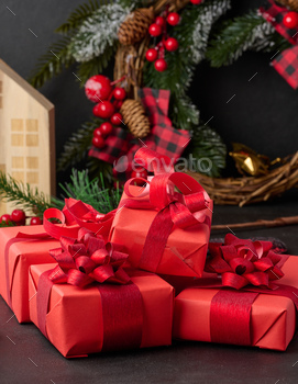 Gift boxes wrapped in red paper against Christmas decor background