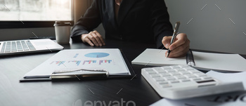 Younger businesswoman works on charts and graphs displaying organizational results.