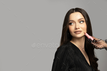 Magnificent younger lady with lipstick in her hands