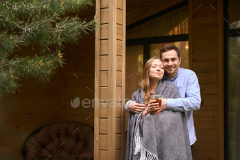 Man hugging his distinguished other whereas she drinking tea