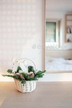 Tiny wicker basket with Christmas reward put aside created from sweets and fir branches