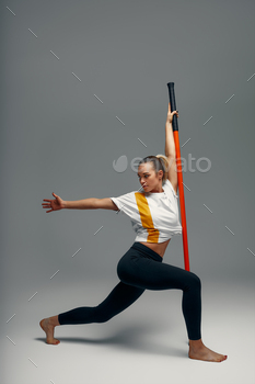 A fighter shirtless in gloomy shorts, stands in a combating artificially pose and holds a try in opposition to stick