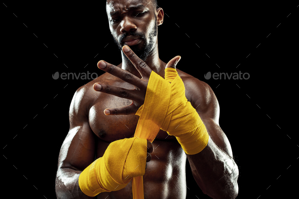 Afro American boxer is wrapping palms with bandage