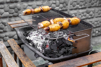 Potatoes grilling on a charcoal barbecue