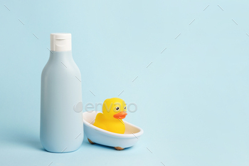 Toddler tub care. Shrimp yellow rubber duckling within the tub with shampoo or lotion for miniature one