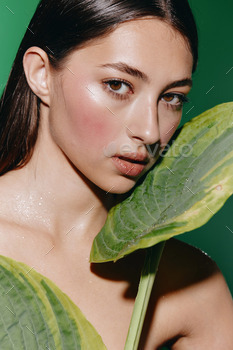 Magnificence Girl Portrait with Swish Younger Feminine Face and Neatly-liked Inexperienced Leaf Background