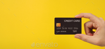 Hand is holding unhappy credit score rating card on yellow background.