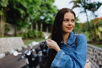 Portrait of a woman brunette smile with enamel strolling starting air in opposition to a backdrop of palm bushes in