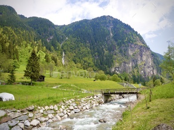 Scenic Serenity: A Majestic River Flowing By the Austrian Alps