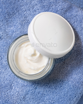 Opened cream jar with white lid on blue towel in bathtub excessive watch, magnificence mockup