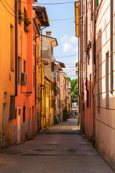 Stare of scenic slim boulevard with frail homes in an inclined city in Europe with blue sky