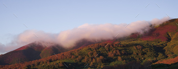 Minimalistic panorama. Cloud above a vibrant mountain. Duplicate function.