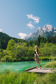 Folks in nature. Vacationer woman with raised arms up in inexperienced nature background.