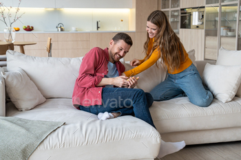 Loving completely happy woman tickling laughing man. Married couple fool round enjoy second of pleasing happiness.