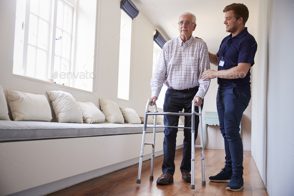 Senior woman the utilization of a strolling body with male nurse at home