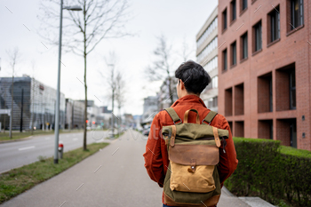 Asian younger man backpacker traveler high-tail forwards and backwards and taking a decide spherical in metropolis.