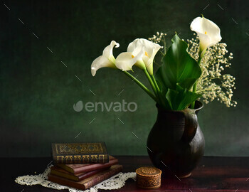 Wonderful calla flora in  vase and books on a desk