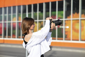 Elegant woman taking picture open air with a analog digicam