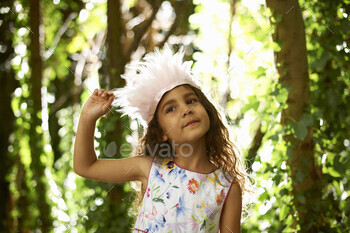 Portrait of comparatively lady carrying feather headdress in wooded area