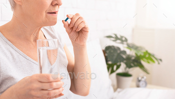 Senior Girl Taking Treatment With a Glass of Water