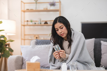 Youthful Girl Sitting on Sofa Conserving Therapy Blister Pack in Relaxed Residing Room Atmosphere