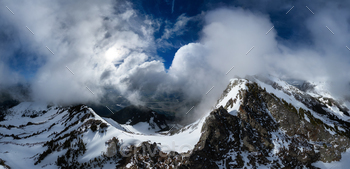 Aerial Canadian Mountain Snow Panorama. Dramatic Sunny Cloudy Day. BC, Canada.