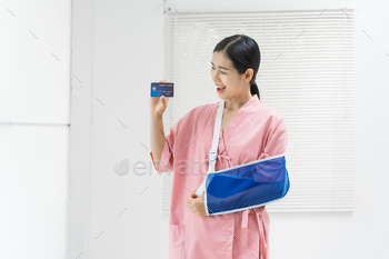 A younger Asian feminine affected individual in a crimson uniform, remoted, with an injured arm in a sling.