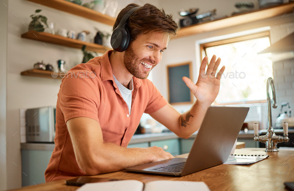 Younger ecstatic caucasian businessman sporting headphones and greeting on a digital meeting on a computer