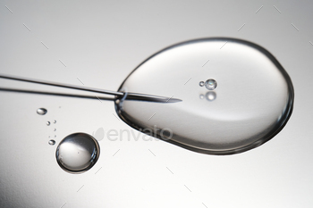 A descend of medicine flowing from a syringe with a needle.