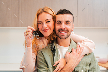 Caucasian couple holding and exhibiting the precept to their glossy home or home to the digicam. Ecstatic