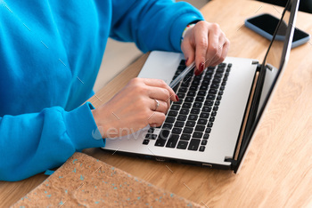 cropped picture particular person working or studing at pc, palms preserving pen above the keyboard