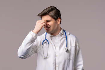 30s outmoded doctor man in white scientific coat invent having headache, studio portrait.Man hanging arms