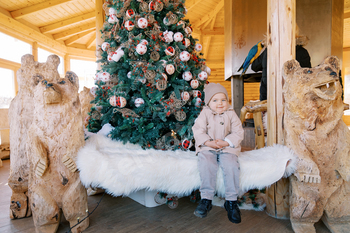 Runt lady sits on a bench lined with white fur with wooden bears on each aspect attain a adorned