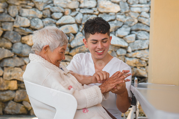 Caregiver Serving to Aged Girl Exterior, Depicting Compassion and Improve