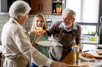 Affectionate senior grandparents in devour with youngsters in kitchen