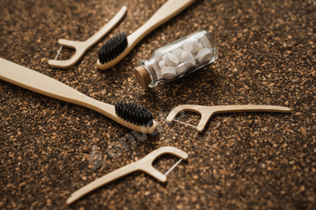 Bamboo Toothbrushes, Floss Picks and Toothpaste Capsules on Cork Floor