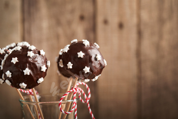 Marry Christmas candy cake pops. Christmas dessert spherical brownie cake pops with stars topping on dar