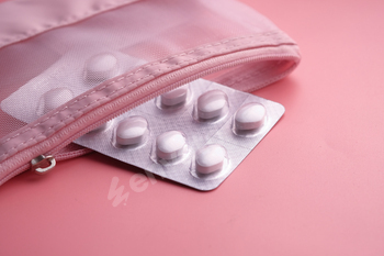 A collection of tablets organized in a purple pouch sitting upon a young purple background