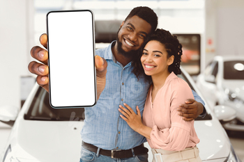 African Spouses Displaying New Car Key To Digicam In Dealership