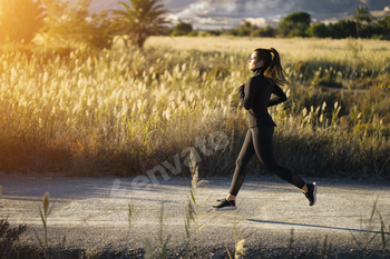 A girl joyfully runs by the gorgeous nature for the size of the ultimate discover golden hour