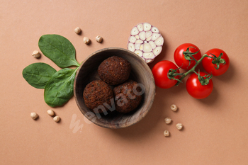 Prepared falafel with elements on a brown background.